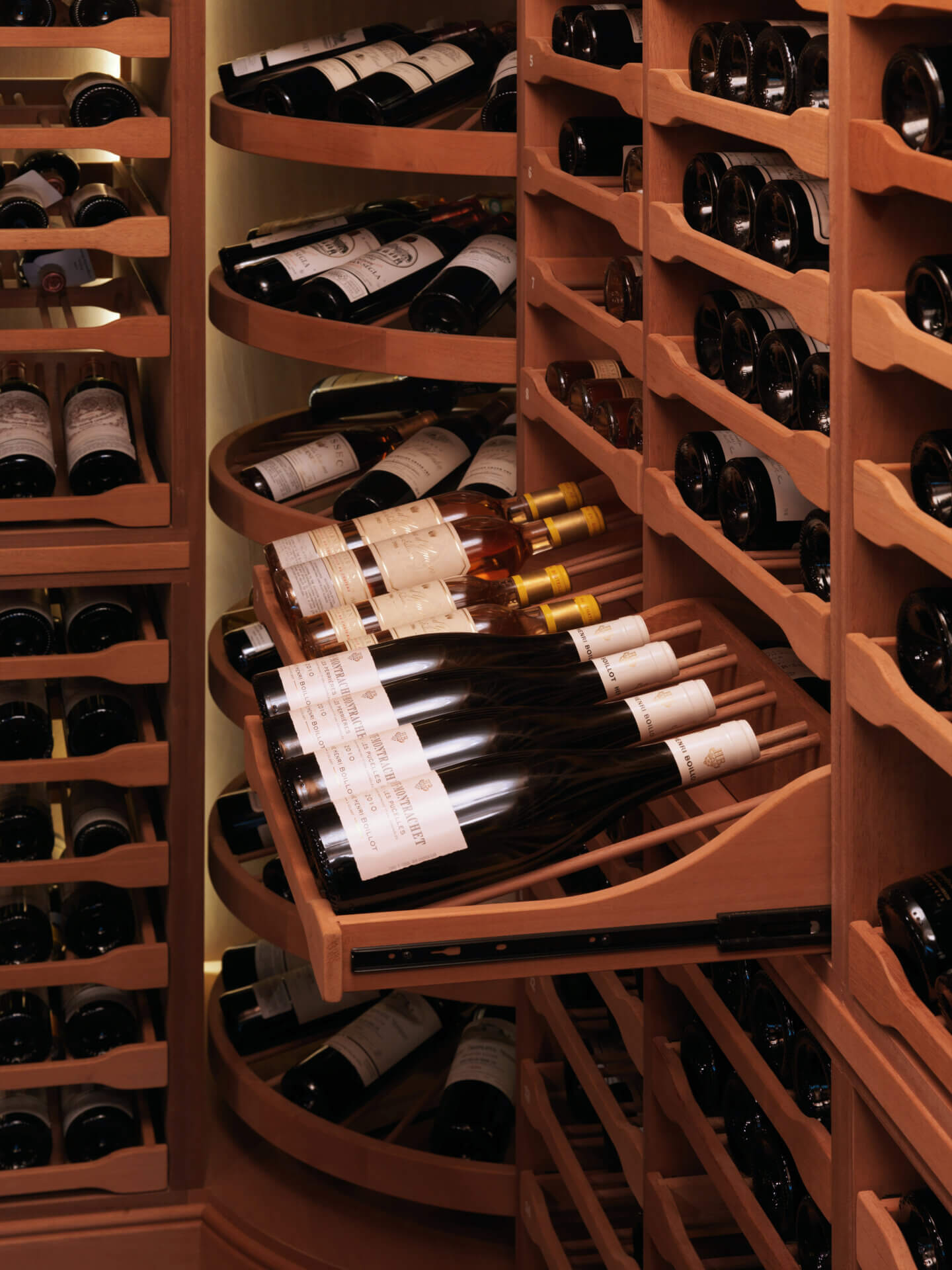 Mahogany wine cellar with pullout trophy drawers displaying wine labels